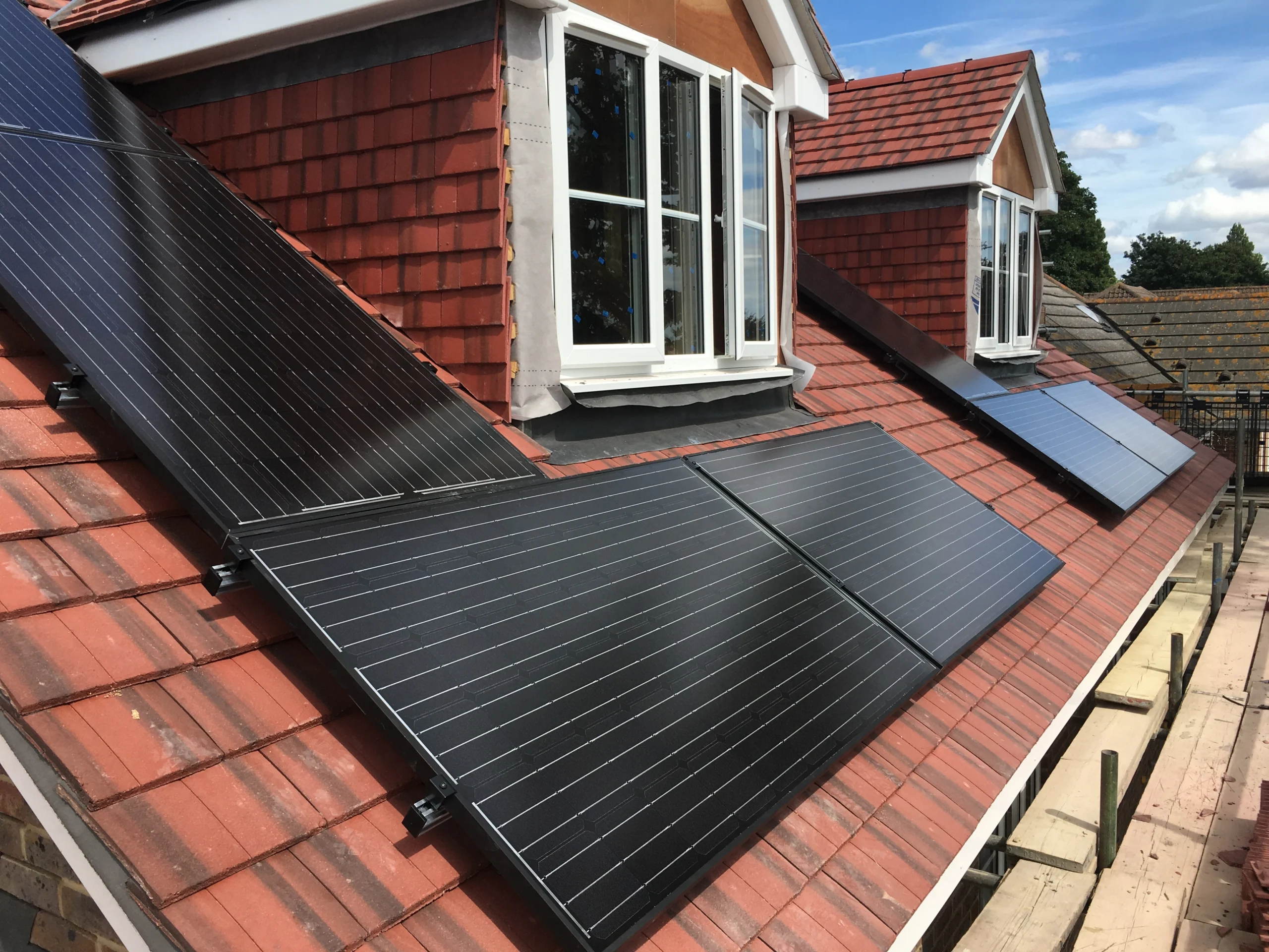Black solar panels fitted around a dormer window