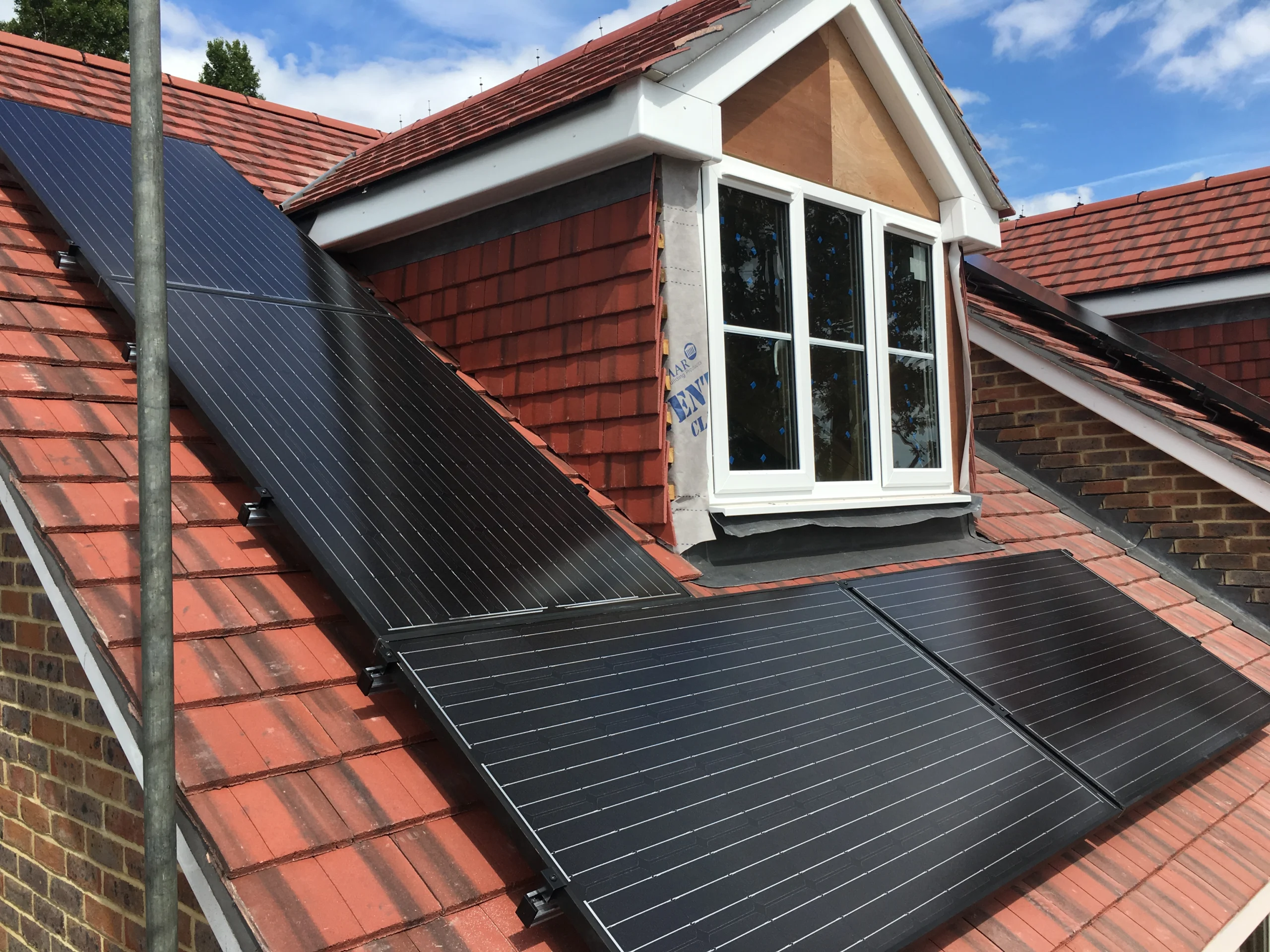 Black solar panels fitted around a dormer window